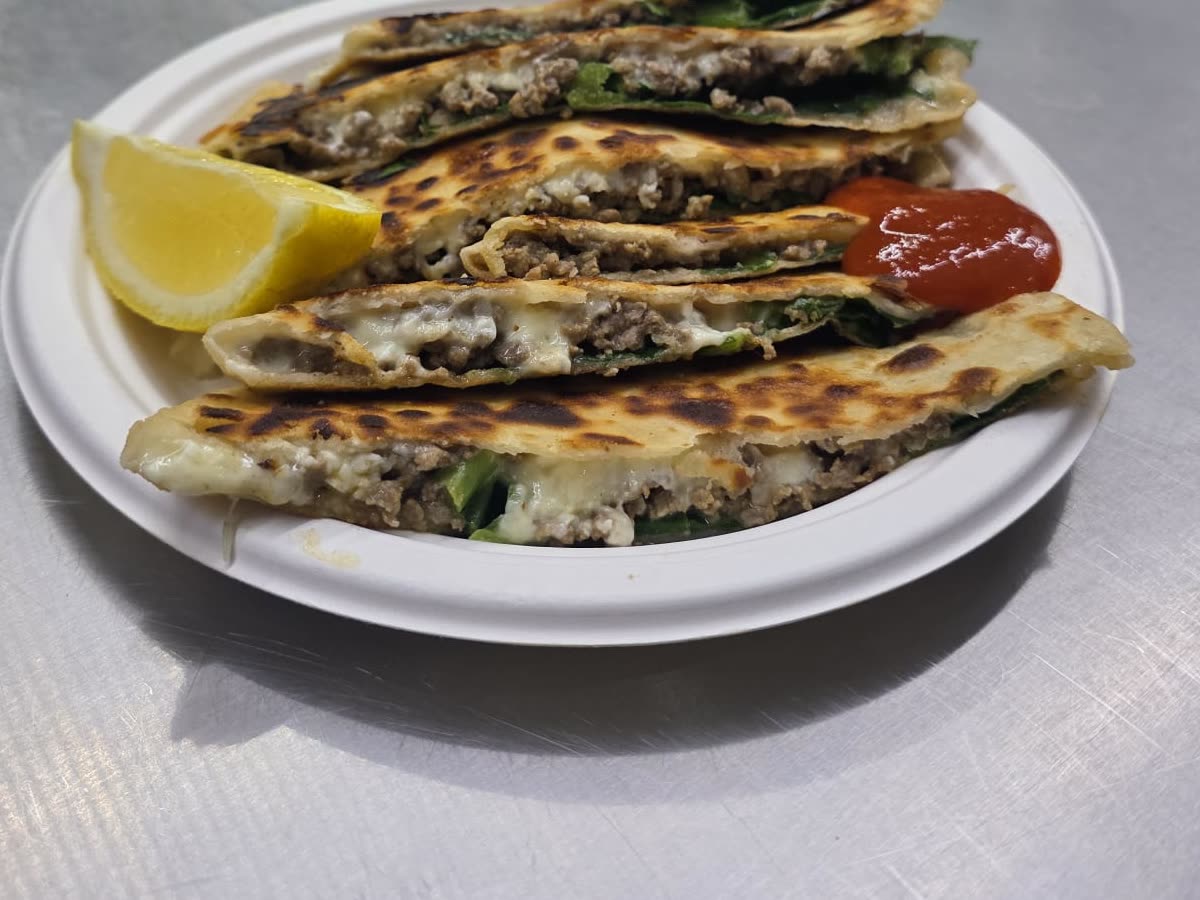 Golden blistered gözleme pastry fresh off the hot plate